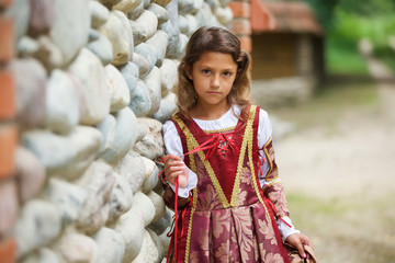 Girl in medieval attire near the old castle.
