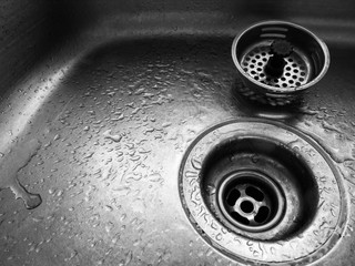 Close up of sink drain with water droplets