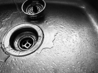 Close up of sink drain with water droplets