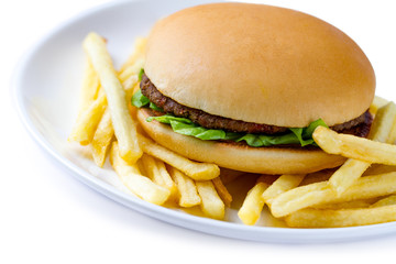 French fries and hamburger on a plate on a white background. Junk and bad food. Fast food addiction