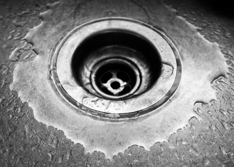 Close up of sink drain with water droplets