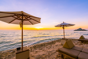 Umbrella and chair with pillow around beautiful landscape of beach and sea