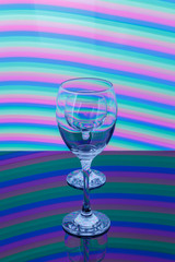 Wine glass with pink, blue, turquoise, orange, green, yellow neon stripes in the background.