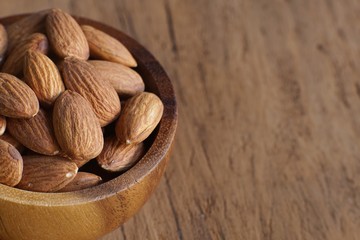 Almond nut in wood bowl on wooden table background