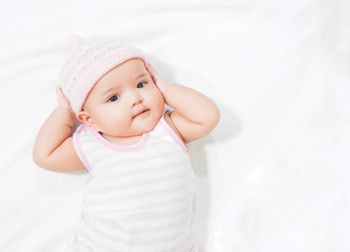 Asian baby wear pink knitting hat on white towel background