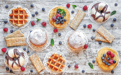 Dessert food top view backgraund. Donuts, pancakes, waffles backgraund. Sweet pastries, puff pastry, powdered sugar.