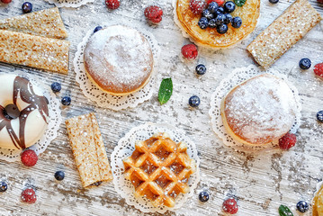 Dessert food top view backgraund. Donuts, pancakes, waffles backgraund. Sweet pastries, puff pastry, powdered sugar.