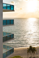 Beautiful view of the ocean from the hotel in the early morning. Balconies of the hotel, the reflection of the sun in the ocean sandy beach with palm trees.