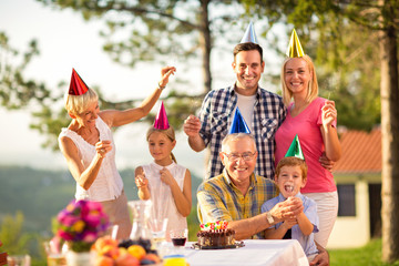 Portrait of a family in party hats and sprinklers.