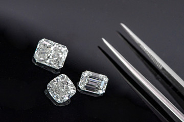 Multi shape of fancy diamonds with tweezers on black background