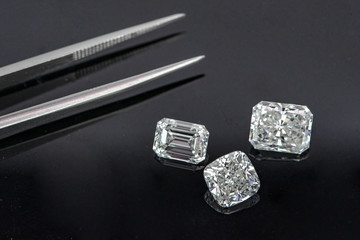 Multi shape of fancy diamonds with tweezers on black background