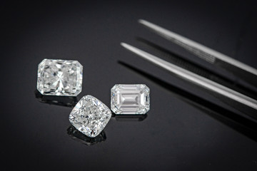 Multi shape of fancy diamonds with tweezers on black background
