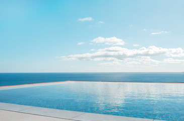 Fototapeta na wymiar Luxury swimming pool in front of the sea. Swimming pool with beautiful sea and sky view.