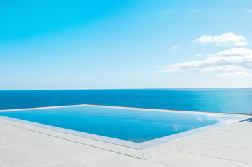 Luxury swimming pool in front of the sea. Swimming pool with beautiful sea and sky view.
