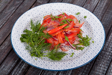  juicy, summer vegetable salad cutting from fresh vegetables and greens in a beautiful serving on a wooden table for decoration and design