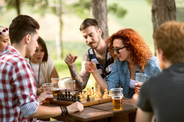 Friends playing chess and drinks beer