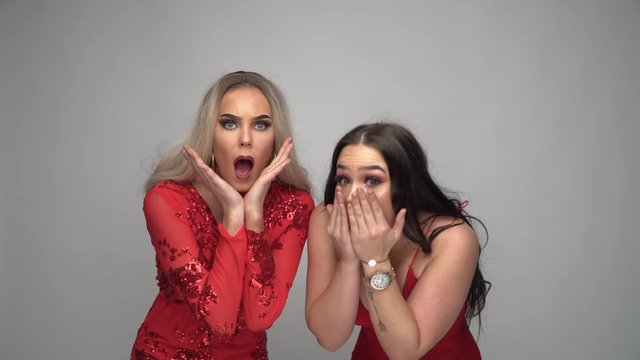 Zwei junge Frauen im roten Kleid Reaktion Schreck, Unglaube Version 2