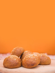 Tasty buns with sesame, on wooden background