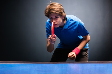Young boy playing ping pong table tennis