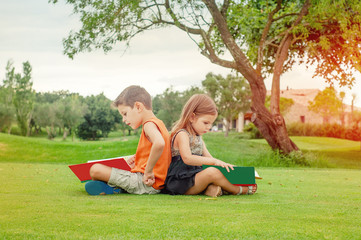 Fototapeta premium Children reading books in the park.