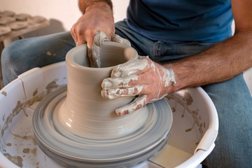 Professional potter making bowl in pottery workshop, studio.