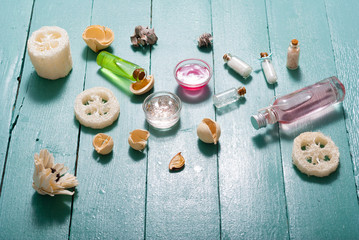 shampoo, shower gel, perfume and bath salt samples on wet old blue wood table background