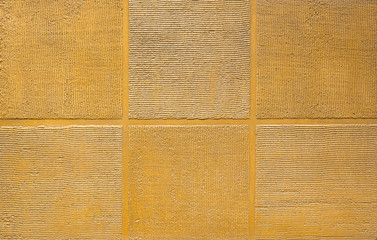 Photo of old gold cement wall with fractures. Texture for pattern.