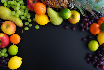 different fresh healthy fruits on black background