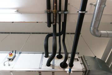 metal and plastic pipe system on the cellar ceiling of an apartment building