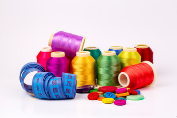 Colored thread coils on white background, sewing, place for text