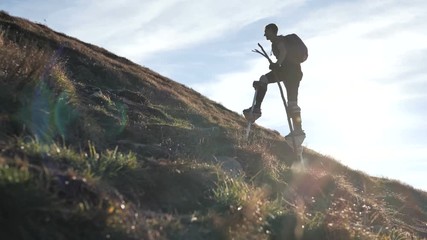 4k slow motion - man on the stilts goes in to the mountain.