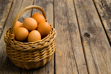 basket of eggs on old wooden background