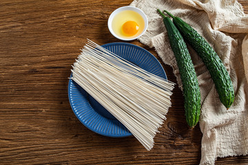 Preparing fresh cucumbers and eggs for making noodles