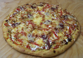 Hand made pizza on the wooden board.