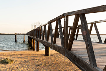 Puente de madera en playa.