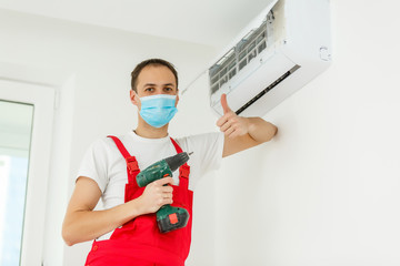 Fototapeta na wymiar Happy Male Technician Repairing Air Conditioner With Screwdriver