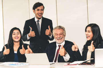 Senior caucasian manager working in office with assistance of young Asian business people and...
