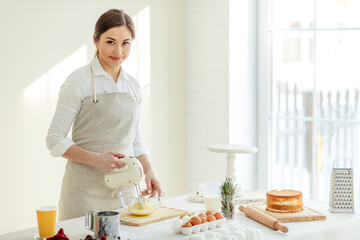 Young gorgeous woman posing to the camera while cooking cake. close up photo. copy space.occupation