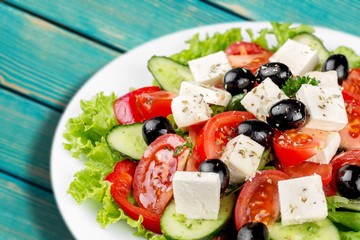 Greek salad with fresh vegetables on background