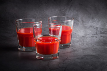 Tomato juice on a gray concrete background