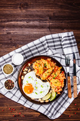 Grilled chicken meat with groats and fried egg on wooden table