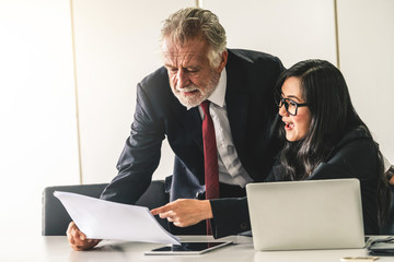 Senior executive manager and young businesswoman working in meeting room in the office. The woman...