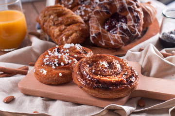 Fresh pastries for Breakfast on a wooden Board. Wooden background
