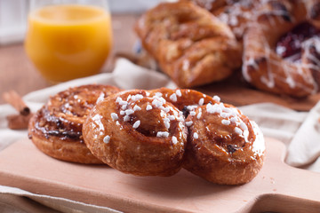 Fresh pastries for Breakfast on a wooden Board. Wooden background