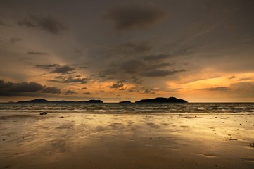 Sunset on the tropical sandy beach during low tide on the Koh Chang island in Thailand.