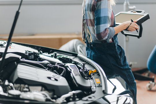 mechanis using code readers and scan tools at work . close up side view cropped photo