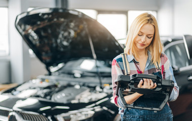 attractive lovely girl controlling the systems in modern automobiles. close up photo