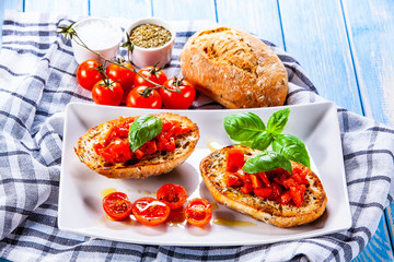 Bruschettas on white plate on wooden background
