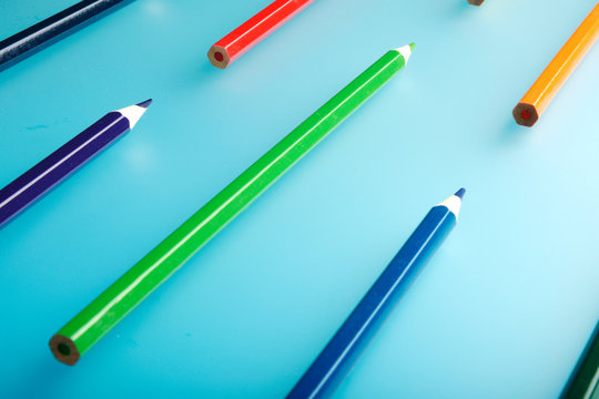 The pencil is laid on a blue background. A lot of colorful pensils. Pensil background.