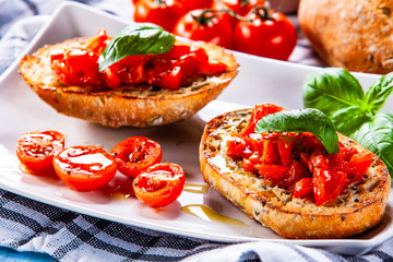 Bruschettas on white plate on wooden background
